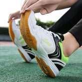 White and green athletic sneakers with gum soles, mesh panels, and lace-up fit on outdoor court