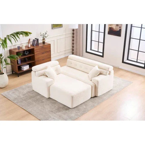 Modern cream upholstered sofa with plush cushions and adjustable armrests on a gray rug