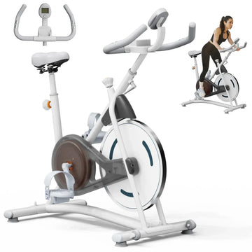 Woman wearing black fitted athletic wear using a white stationary exercise bike indoors.