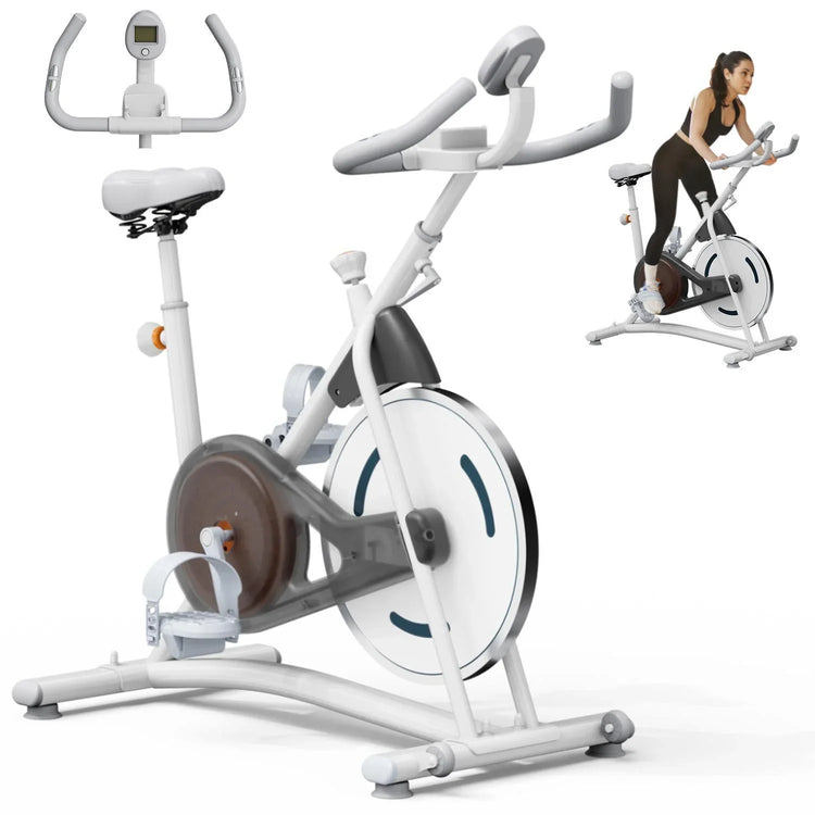Woman wearing black fitted athletic wear using a white stationary exercise bike indoors.