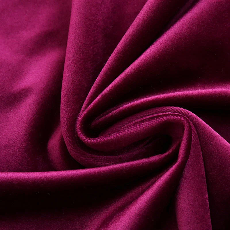 Close-up of plush velvet fabric in deep magenta, soft texture and rich color