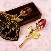 Gold-plated rose with red crystal bud, thank you tag, gift box on pink floral background