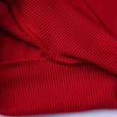 Close-up of red ribbed cotton sweatshirt cuff showing soft texture and stitching detail