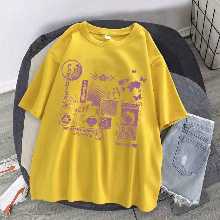 Yellow oversized short-sleeve graphic t-shirt with purple futuristic prints, paired with light wash denim shorts.