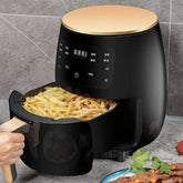 Black digital air fryer with gold accents cooking French fries on kitchen counter