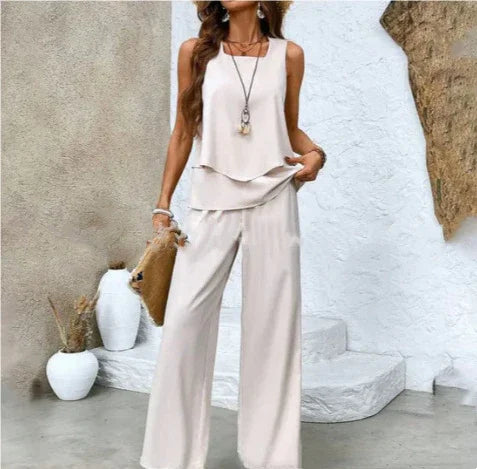 Woman wearing loose beige sleeveless top and wide-leg pants set, relaxed fit, lightweight fabric.