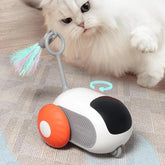 Fluffy white cat playing with a modern robot cat toy with orange wheels and feather teaser