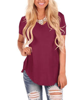 Woman wearing a burgundy short-sleeve V-neck top with relaxed fit and distressed jeans
