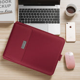 Burgundy faux leather laptop sleeve with slim fit on a wooden desk near a laptop and accessories