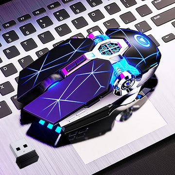 Futuristic black wireless mouse with blue LED lights and geometric design on a laptop keyboard