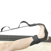 Black elastic foot stretcher strap on foot, adjustable fit, minimalist style