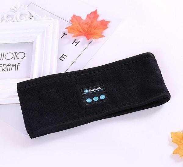 Black fleece Bluetooth headband, soft fabric, tech accessory laid flat on white background