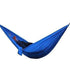 Person lounging in a royal blue nylon hammock, relaxed fit, casual outdoor setting