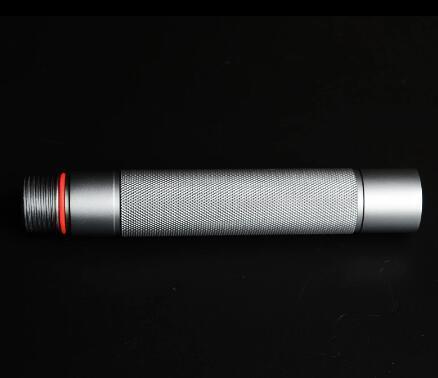 Silver cylindrical metal accessory with knurled texture and red ring, on black background
