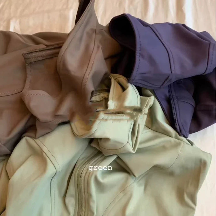 Assorted streetwear zip-up jackets in muted sage green, taupe, and deep purple, soft fabric.