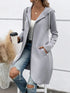 Woman wearing light gray long zip hoodie, white tank top, ripped blue jeans, casual streetwear