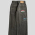 Wide-leg black denim jeans with large back pockets, contrast stitching, and colorful patches.