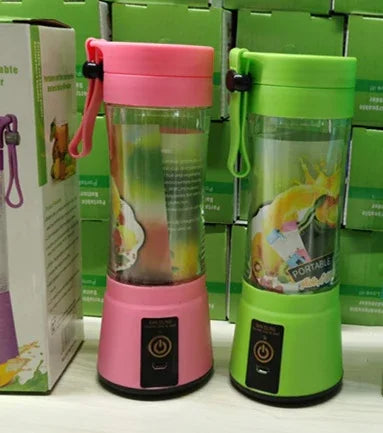 Pink and green portable blenders with clear containers, plastic bodies, and power buttons, displayed side by side.