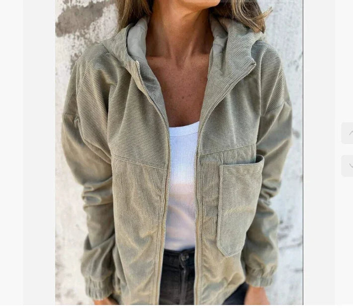 Light khaki corduroy jacket with relaxed fit, front pocket, and hood, styled over white tank top.
