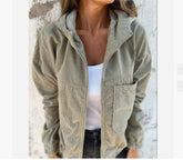Light khaki corduroy jacket with relaxed fit, front pocket, and hood, styled over white tank top.