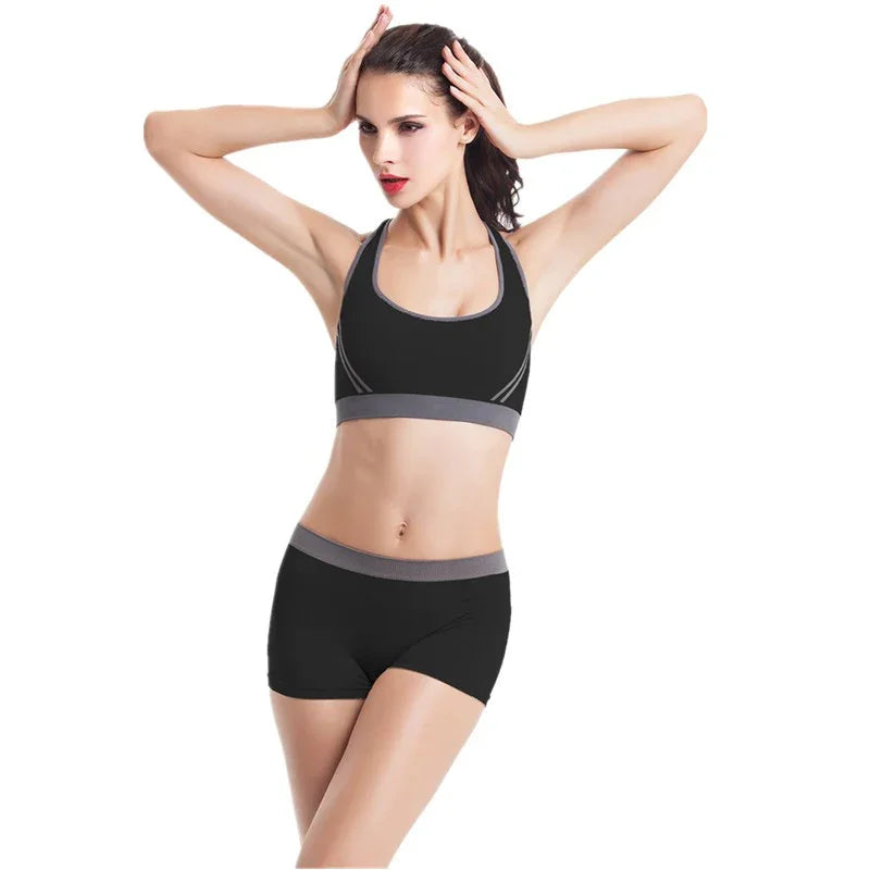Woman wearing black athletic sports bra and shorts with gray trim, fitted activewear