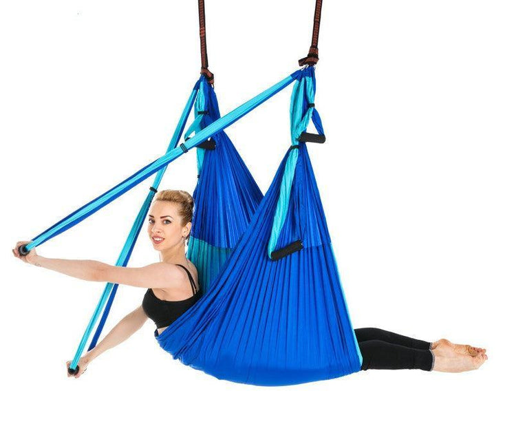 Woman in black activewear using a blue aerial yoga hammock, stretchy fabric, comfortable fit