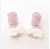 Soft pink ribbed baby socks with white plush angel wings, cozy and cute style for infants