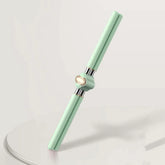 Mint green double-ended pen with a shiny gold rotating center on a minimalist surface