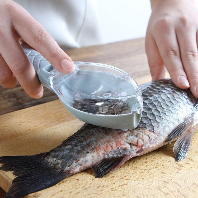 Hand using plastic fish scaler tool to remove fish scales on a cutting board