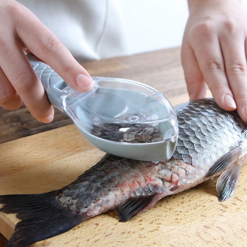 Hand using a fish descaler tool to remove scales from a fresh fish on a wooden cutting board