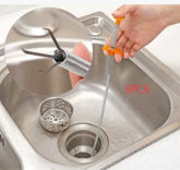 Flexible spring drain clog remover tool with orange handle used in kitchen sink, metal claws extended