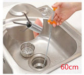 Flexible metal drain clog remover tool with orange handle used in stainless steel kitchen sink