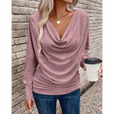 Woman in mauve cowl neck long sleeve top and blue jeans, casual streetwear style