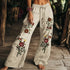 Beige wide-leg linen pants with colorful floral embroidery and relaxed fit