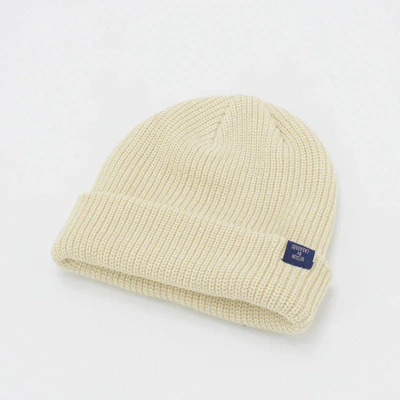 Beige ribbed knit beanie with folded cuff, soft texture, modern streetwear style.