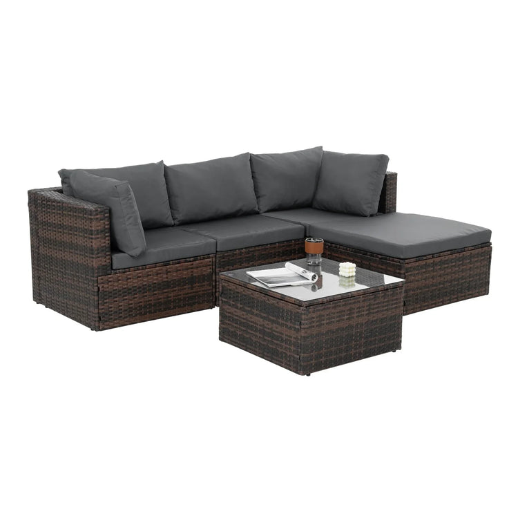 Brown rattan outdoor sectional sofa with dark gray cushions and matching glass top coffee table