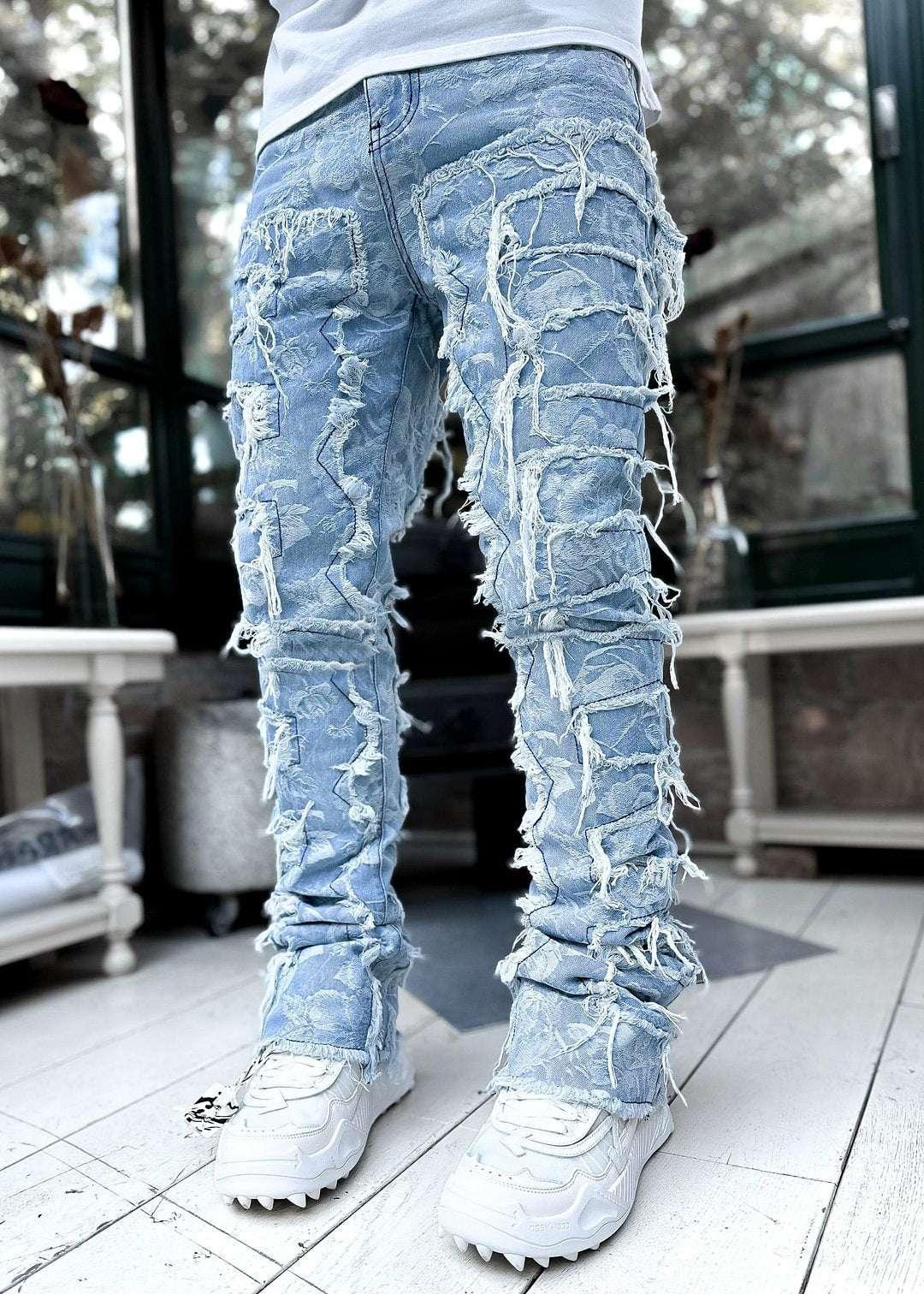 Light blue distressed denim jeans with heavy fraying in a slim fit, paired with white sneakers.