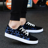 Black low-top sneakers with blue abstract pattern, white soles, white laces, casual fit