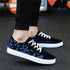 Black low-top sneakers with blue abstract pattern, white soles, white laces, casual fit