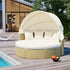 Round outdoor wicker daybed with cream cushions and canopy on a wooden poolside deck