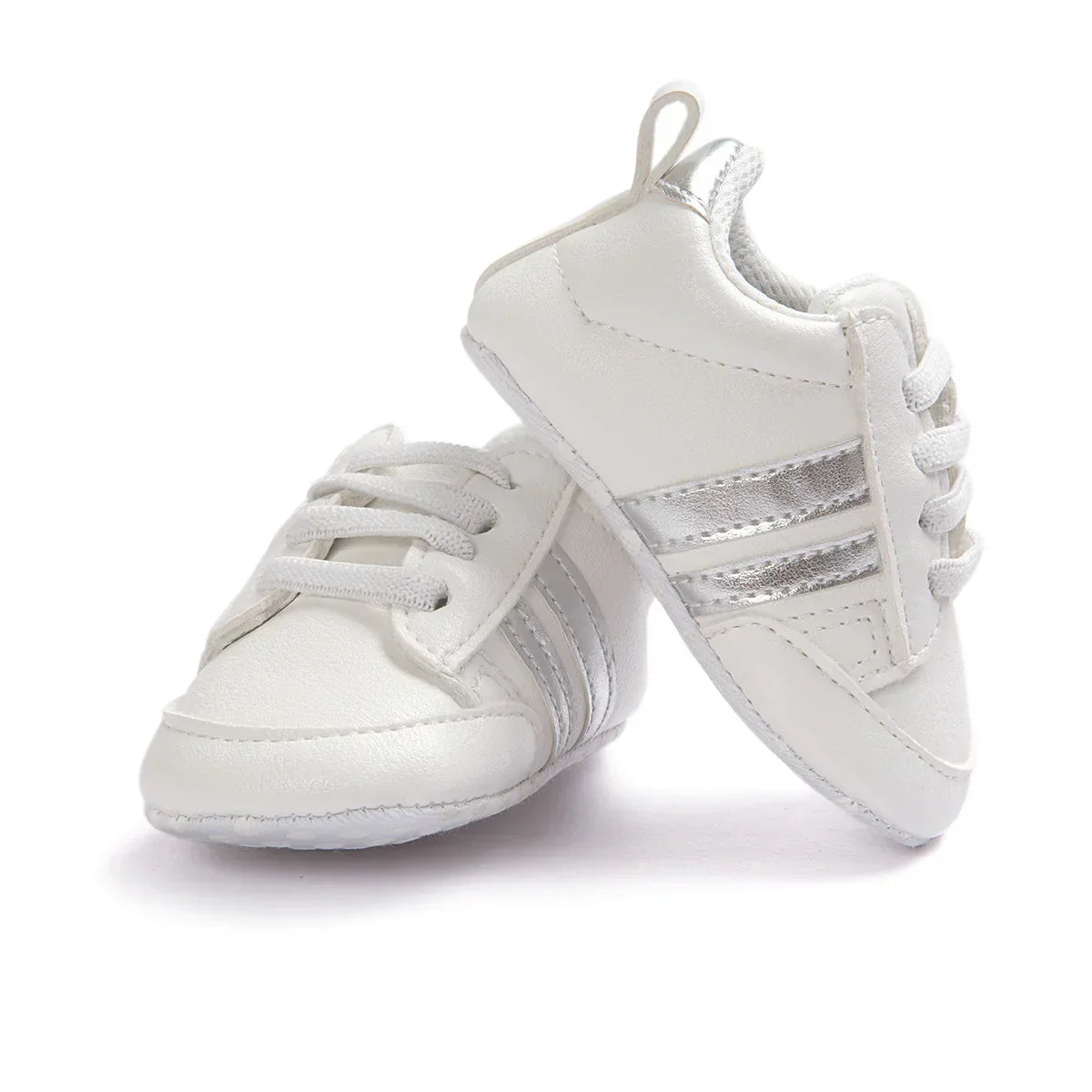 White faux leather baby sneakers with silver stripes, lace-up design, soft sole