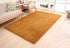 Modern living room with a soft, rectangular, brown shaggy rug on light wooden floor