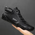 Black leather high-top sneaker with lace-up front, side strap, and bold stitching details