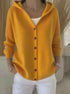 Yellow button-up knit hoodie, relaxed fit, long sleeves, styled with white pants.