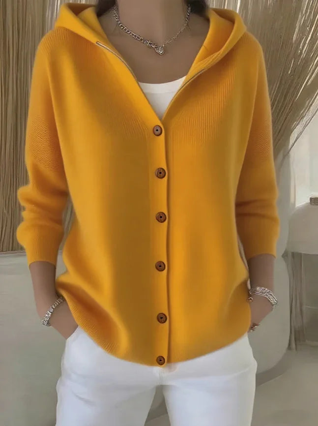 Yellow button-up knit hoodie, relaxed fit, long sleeves, styled with white pants.