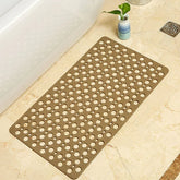 Beige non-slip bath mat with round holes on marble bathroom floor