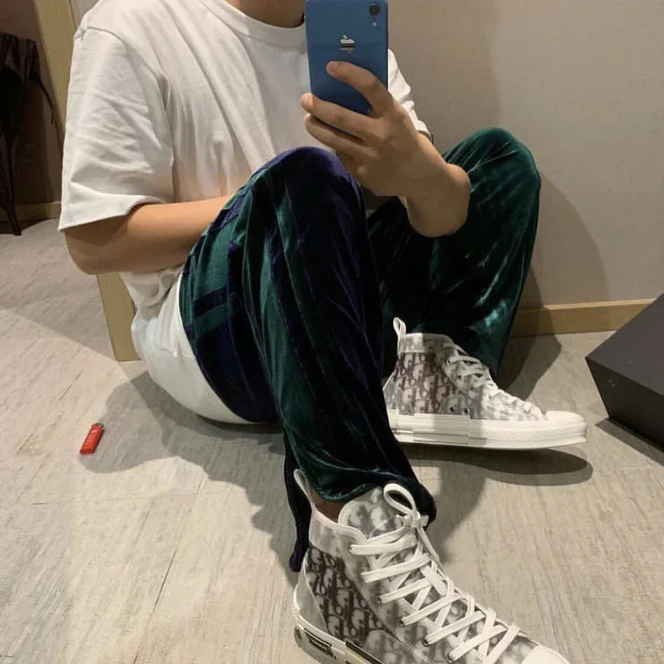 Man wearing relaxed white t-shirt, green velvet pants, and translucent high-top sneakers