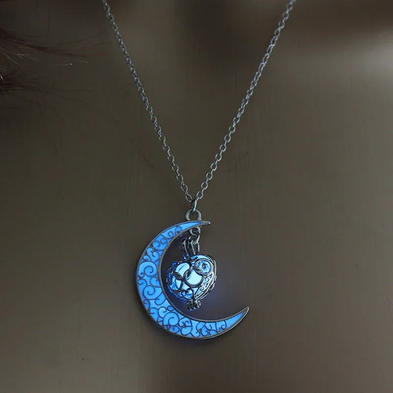 Silver chain necklace with glowing blue crescent moon and filigree heart pendant