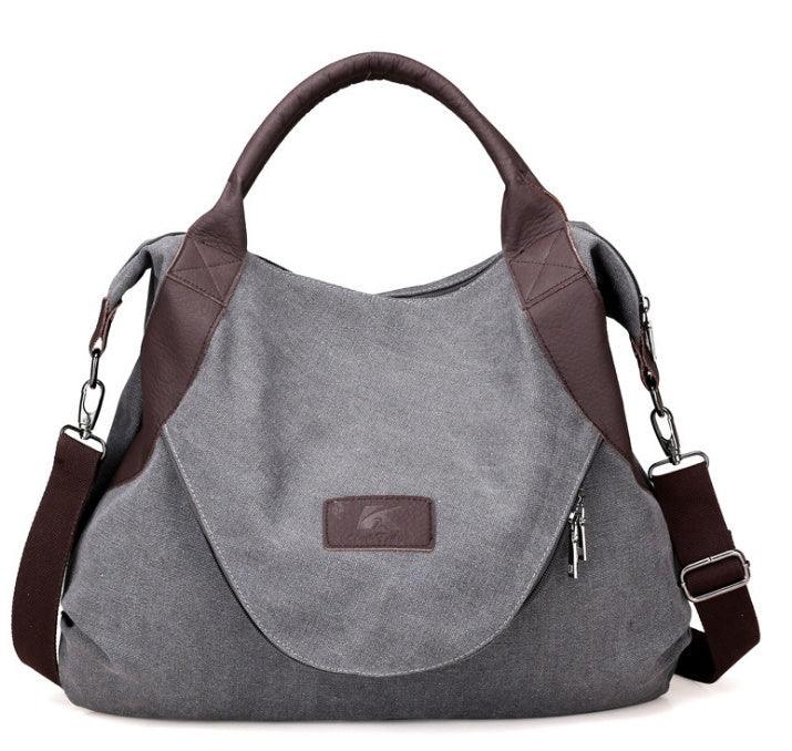 Gray canvas messenger bag with brown leather accents and adjustable shoulder strap