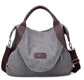 Gray canvas messenger bag with brown leather accents and adjustable shoulder strap